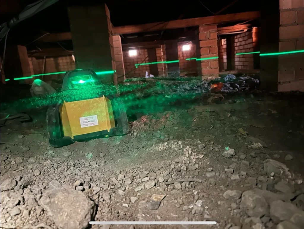 Laser level set up under a Newcastle home during a foundation inspection